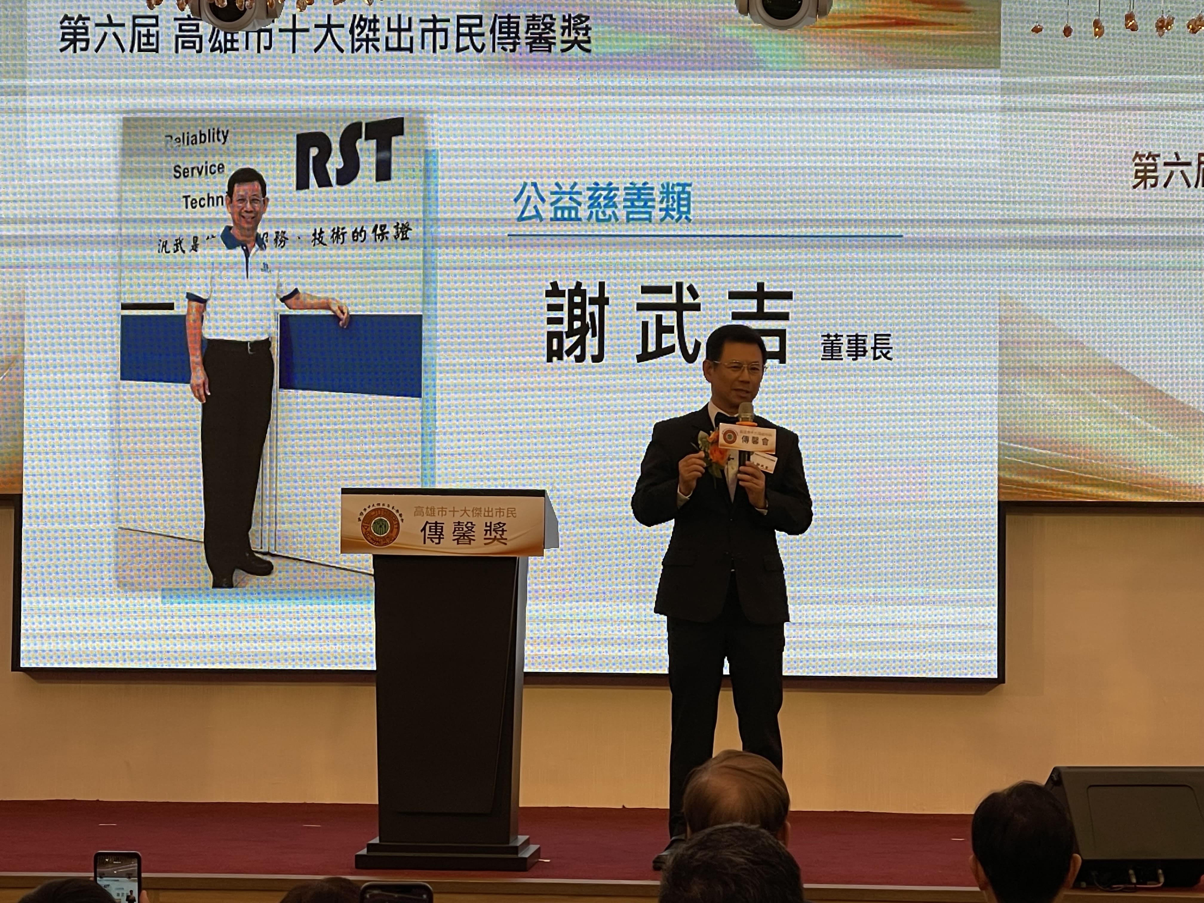 謝武吉董事長在台上拿著麥克風發表感言致詞